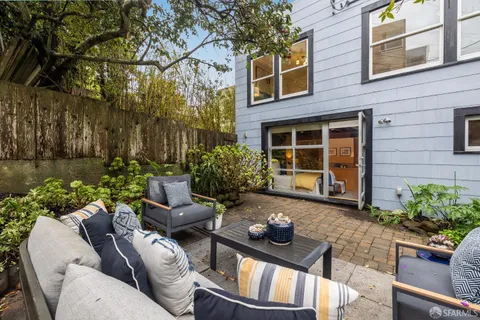 a view of a patio with couches table and chairs and potted plants