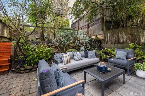 a view of a backyard with furniture and a fire pit