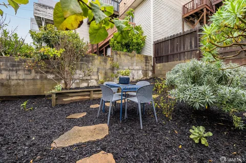 a view of a chairs and table in a backyard