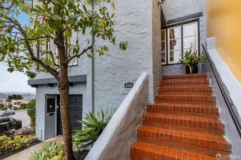 a house with potted plants in front of it