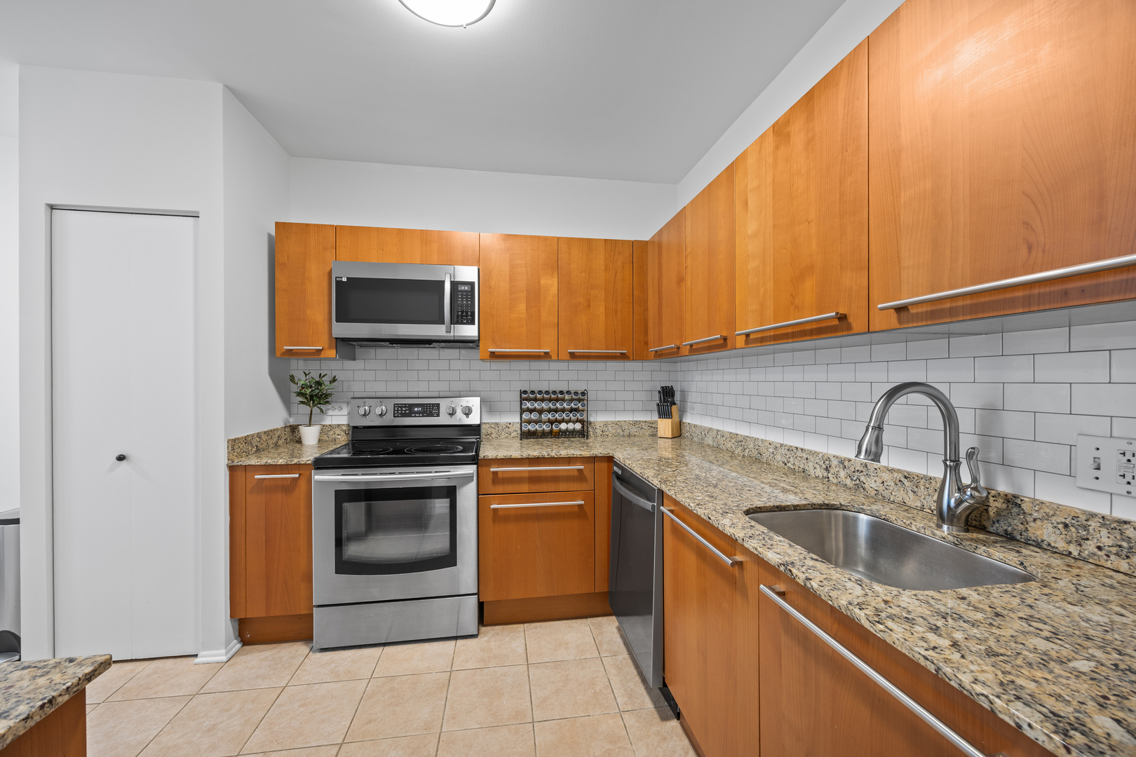 740 South Federal Street, Unit 710 Chicago, IL 60605 - Photo 10 of 23 a kitchen with stainless steel appliances granite countertop a sink stove and refrigerator