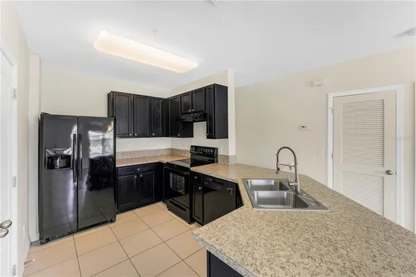 a kitchen with a refrigerator sink and cabinets