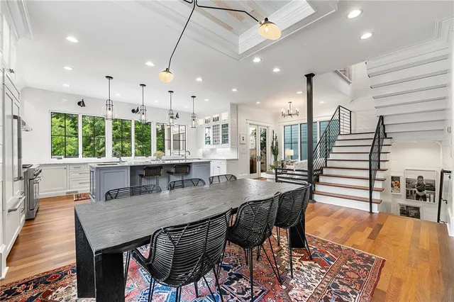 a kitchen with stainless steel appliances granite countertop a table chairs and a refrigerator