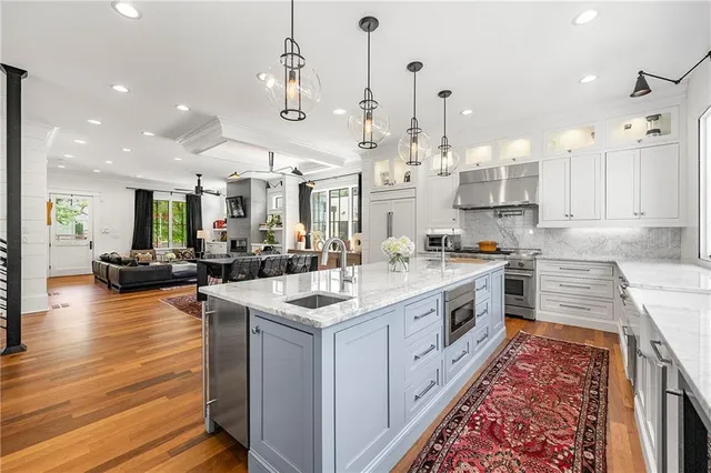 a large white kitchen with lots of counter space sink and appliances
