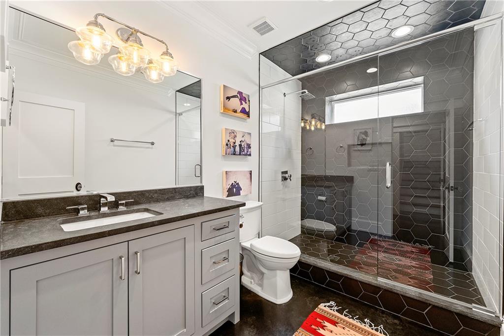 612 Fortune Place Northeast Atlanta, GA 30312 - Photo 32 of 48 a spacious bathroom with a granite countertop sink a toilet a mirror and shower