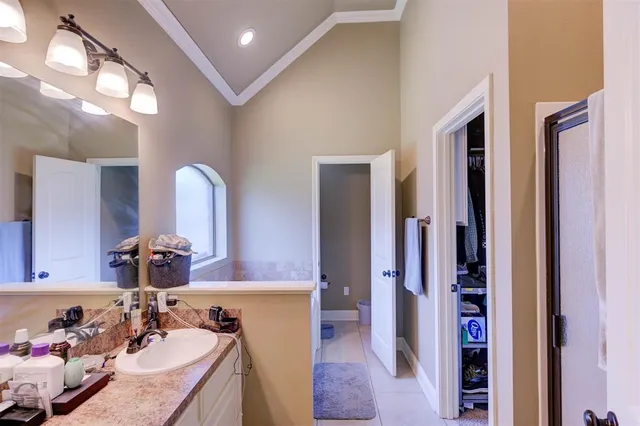 a en suite bathroom with a granite countertop sink and a mirror