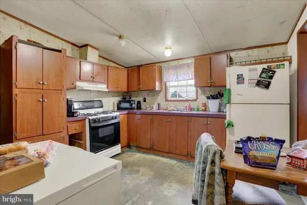 a kitchen with granite countertop a sink appliances cabinets and a counter top space