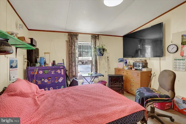 a bedroom with furniture and a flat screen tv