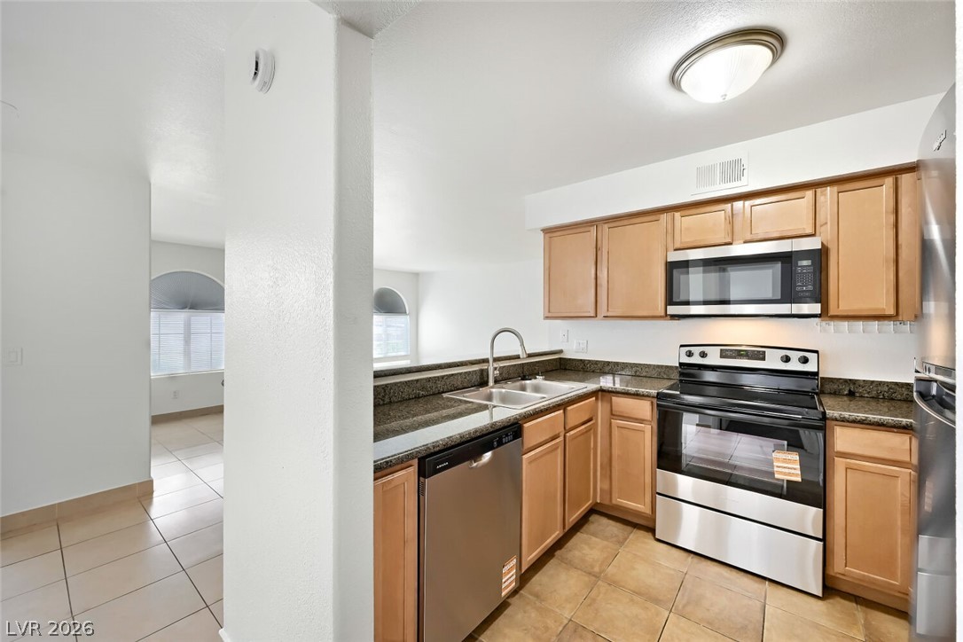 9325 West Desert Inn Road, Unit 177 Las Vegas, NV 89117 - Photo 8 of 24 A functional kitchen provides ample counter space, rich wood cabinetry, and sleek stainless appliances.