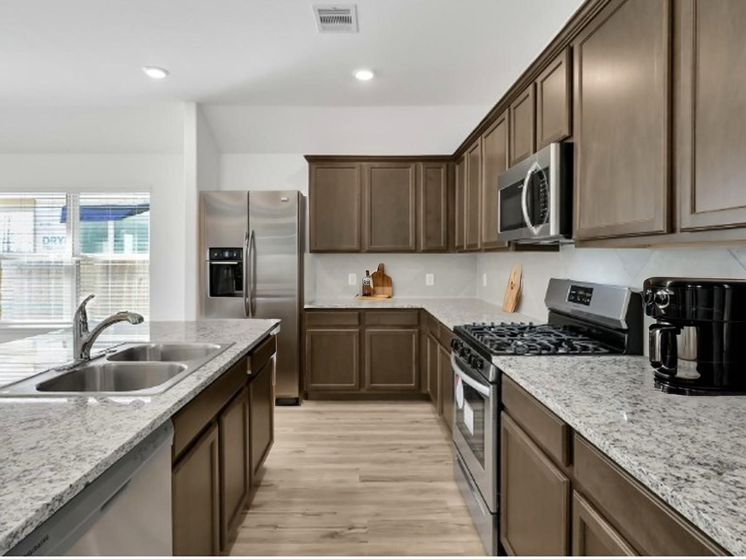 3806 Rock Ledge Drive Rosenberg, TX 77469 - Photo 5 of 23 Functional kitchen layout with granite countertops and modern finishes.