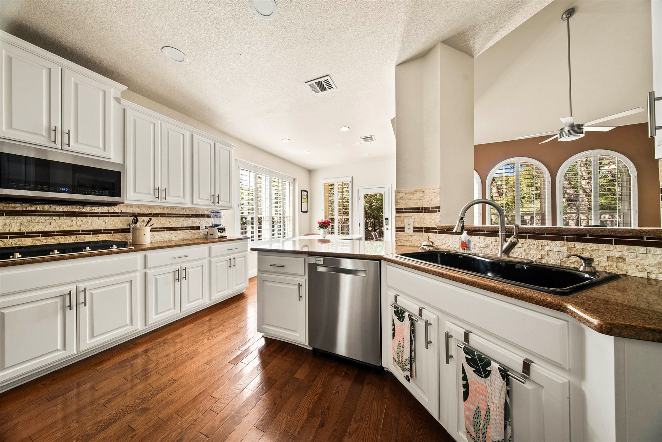 6720 Hansa Loop Austin, TX 78739 - Photo 3 of 38 The kitchen features granite countertops and a tile backsplash, offering plenty of prep space for the home chef
