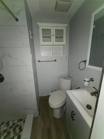 a bathroom with a sink toilet and shower