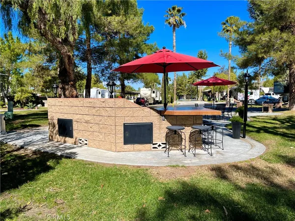 a view of a patio with a table and chairs under an umbrella