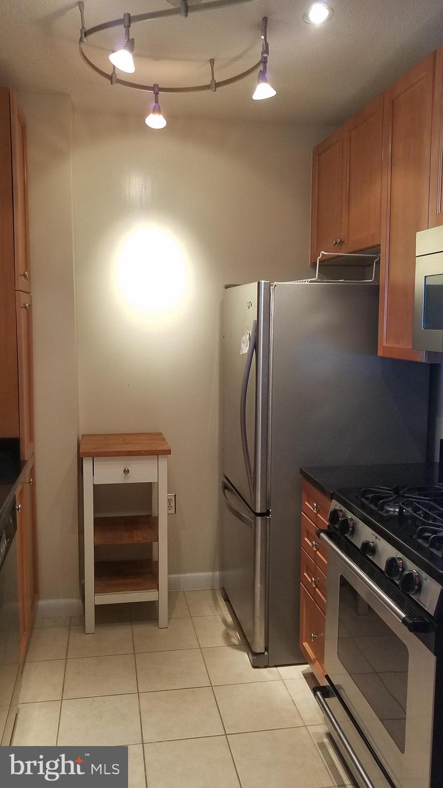 851 North Glebe Road, Unit 1015 Arlington, VA 22203 - Photo 6 of 29 a kitchen with a refrigerator and a stove top oven