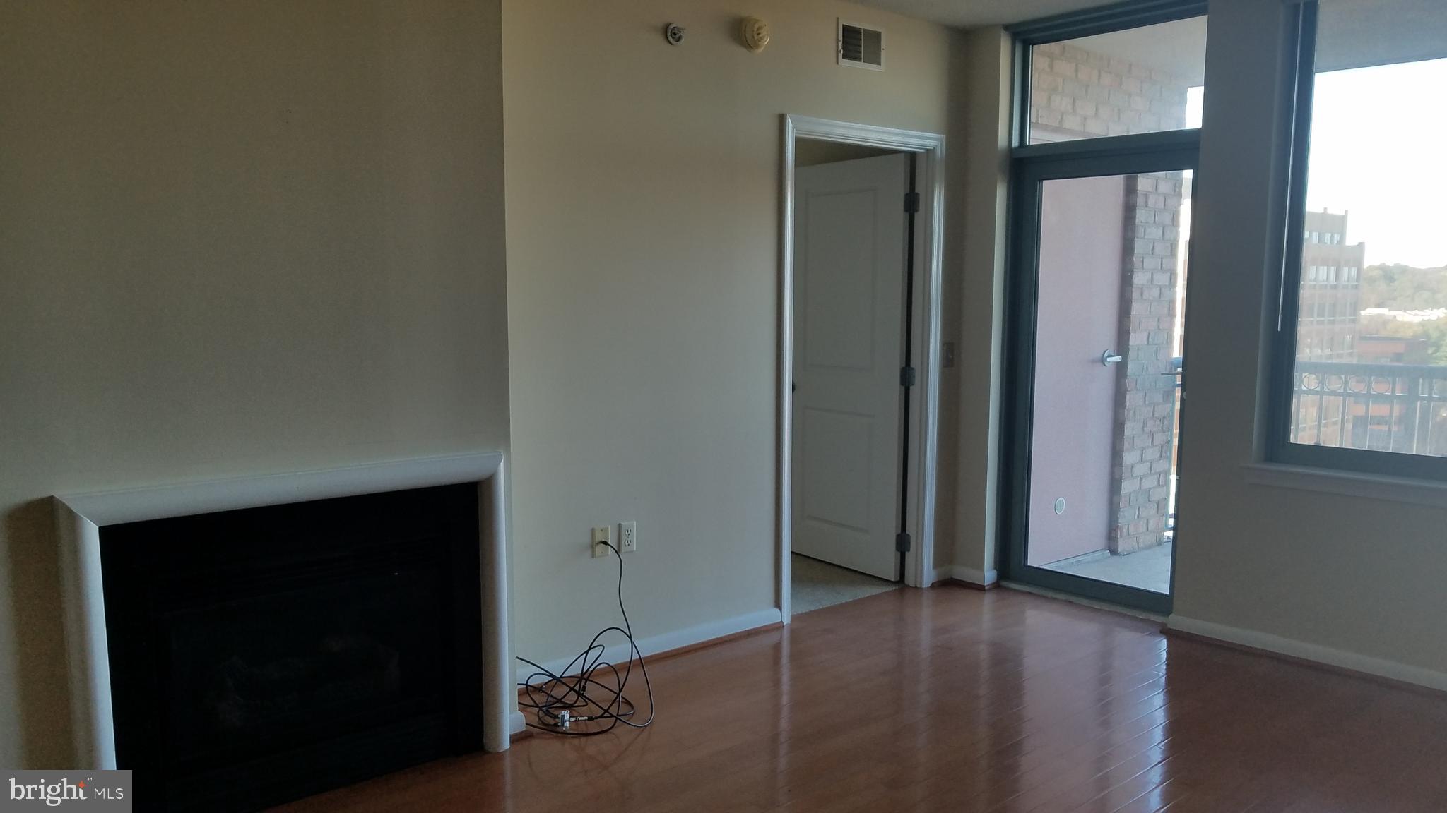 851 North Glebe Road, Unit 1015 Arlington, VA 22203 - Photo 8 of 29 an empty room with wooden floor and windows
