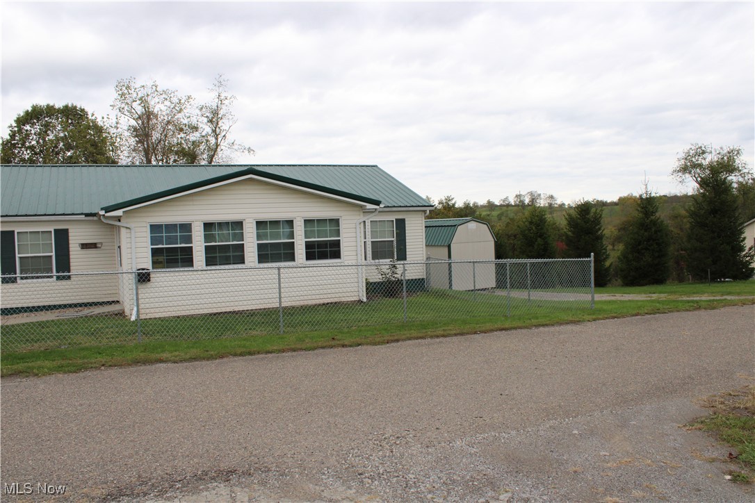 56 3rd Street Rayland, OH 43943 - Photo 3 of 46 View of front of home with a fenced front yard and a metal roof