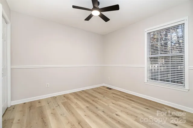 a view of a big room with wooden floor and windows