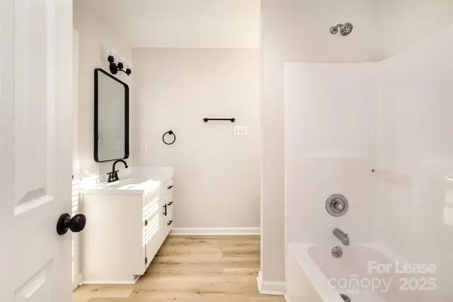 a bathroom with a tub sink and mirror