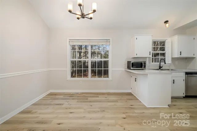 a view of a kitchen with wooden floor and windows