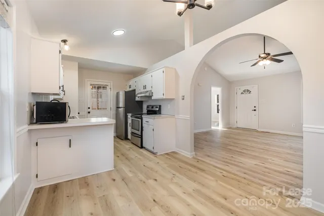 a large kitchen with cabinets and wooden floor