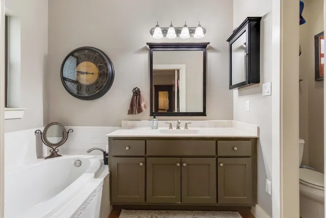 a bathroom with a tub sink and mirror