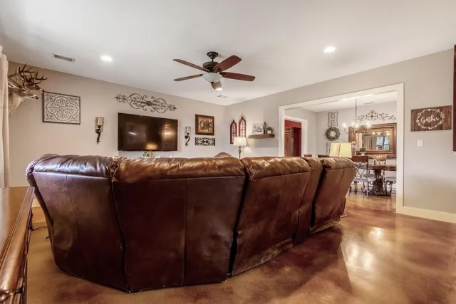 a living room with couches a fireplace and a flat screen tv