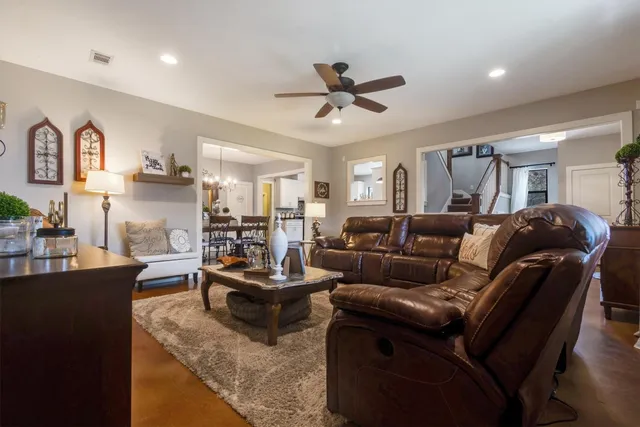 a living room with furniture kitchen view and a window