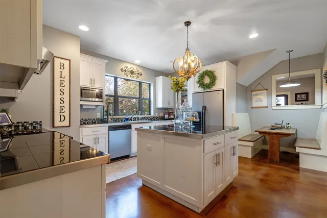 a kitchen with white cabinets and appliances