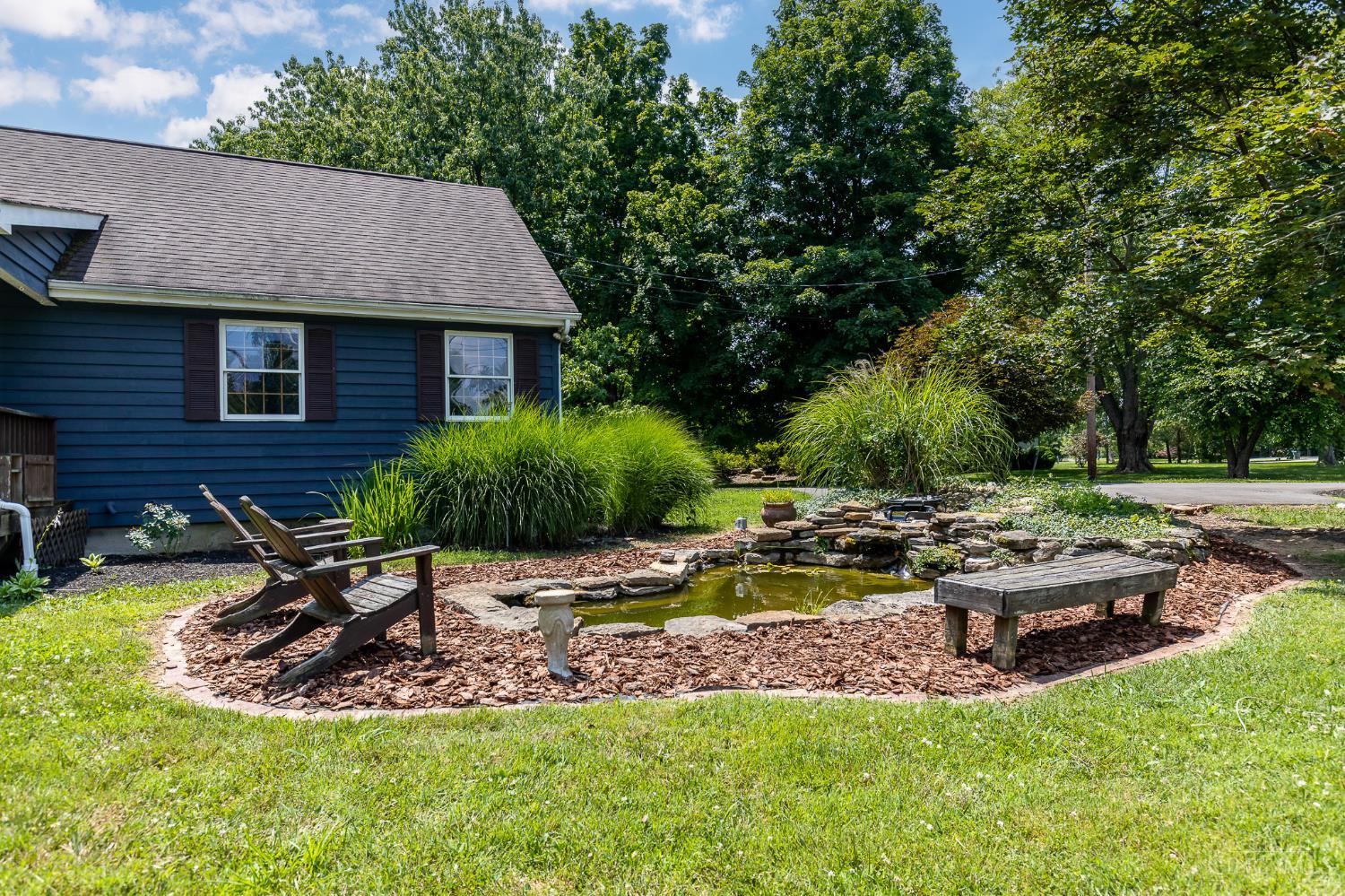 623 Ibold Road Loveland, OH 45140 - Photo 2 of 35 Enjoy the peaceful ambiance of the koi pond, featuring colorful fish and a charming stone waterfall surrounded by mature landscaping.