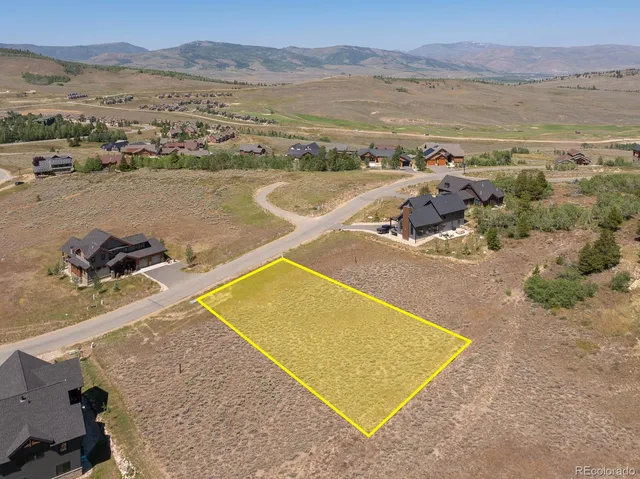 an aerial view of ocean and residential houses with outdoor space
