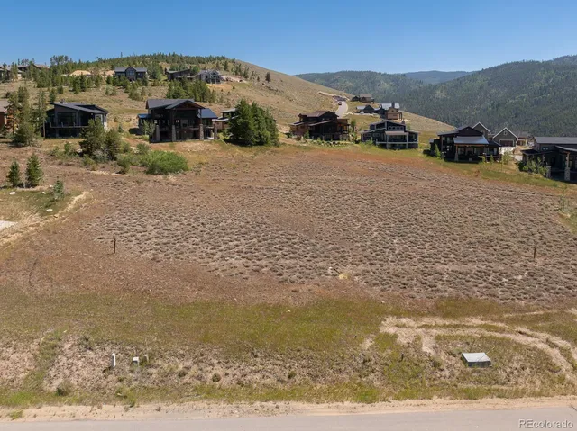 an aerial view of a house with a mountain