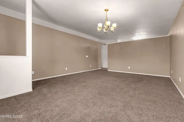 a view of an empty room with a chandelier