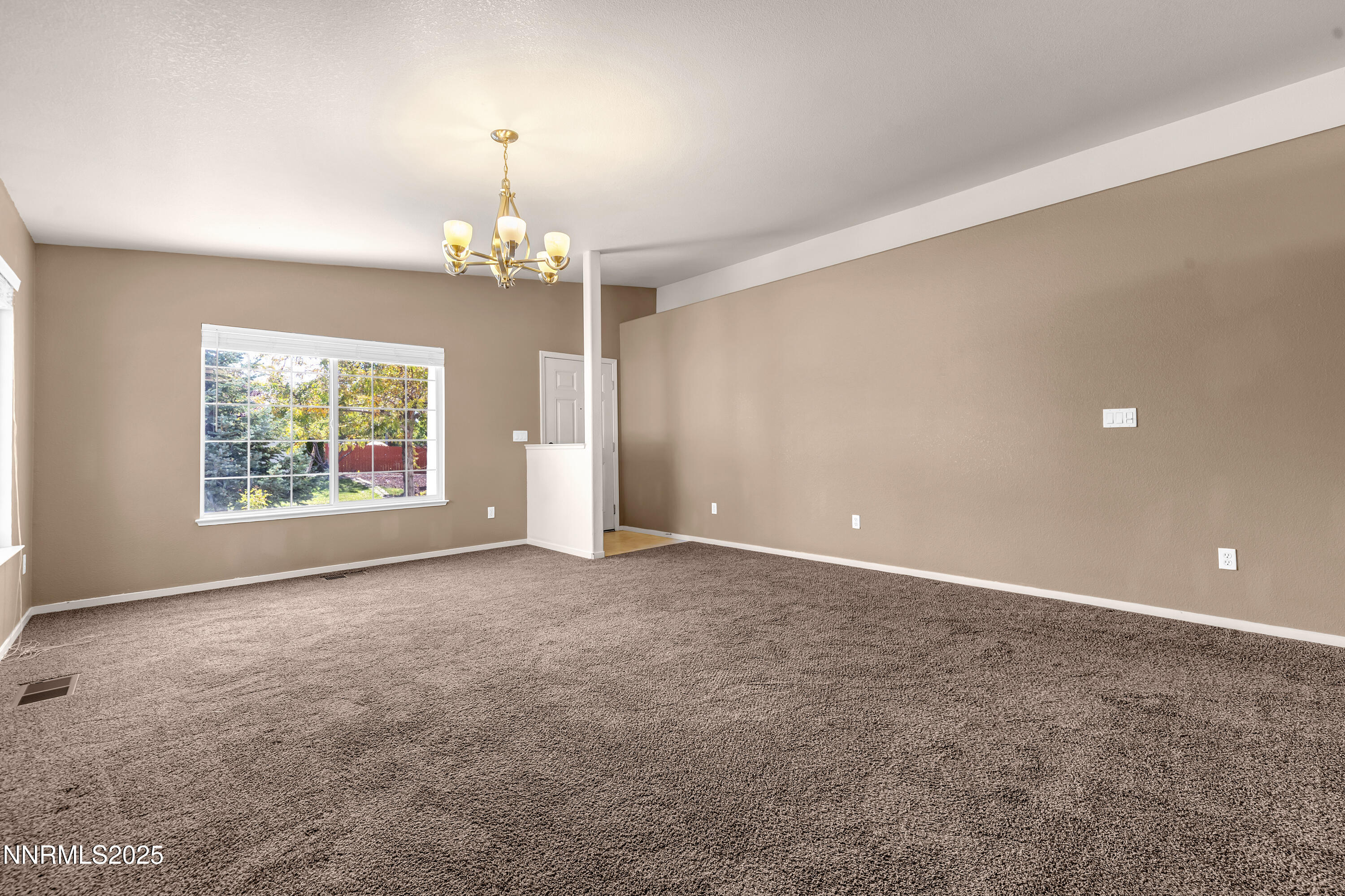 17507 Bear Lake Drive Reno, NV 89508 - Photo 5 of 42 an empty room with windows and chandelier