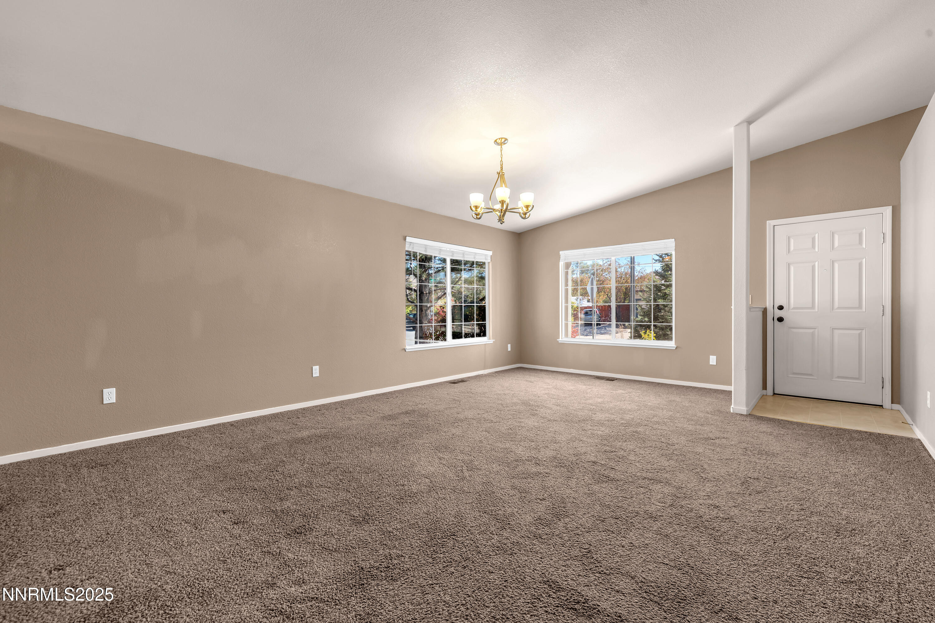 17507 Bear Lake Drive Reno, NV 89508 - Photo 6 of 42 an empty room with chandelier fan and windows