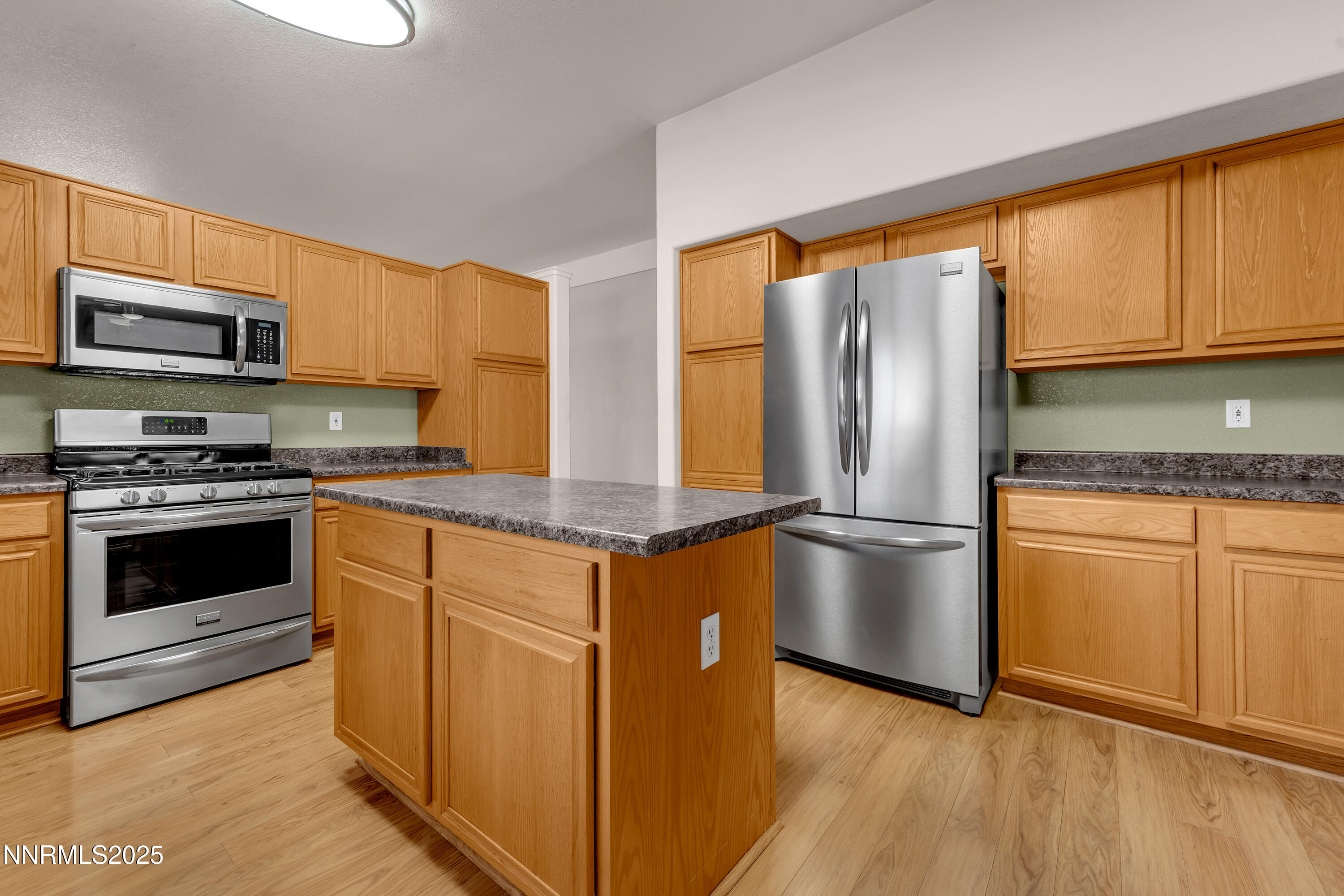 17507 Bear Lake Drive Reno, NV 89508 - Photo 9 of 42 a kitchen with stainless steel appliances granite countertop a refrigerator a stove and a sink with wooden floor