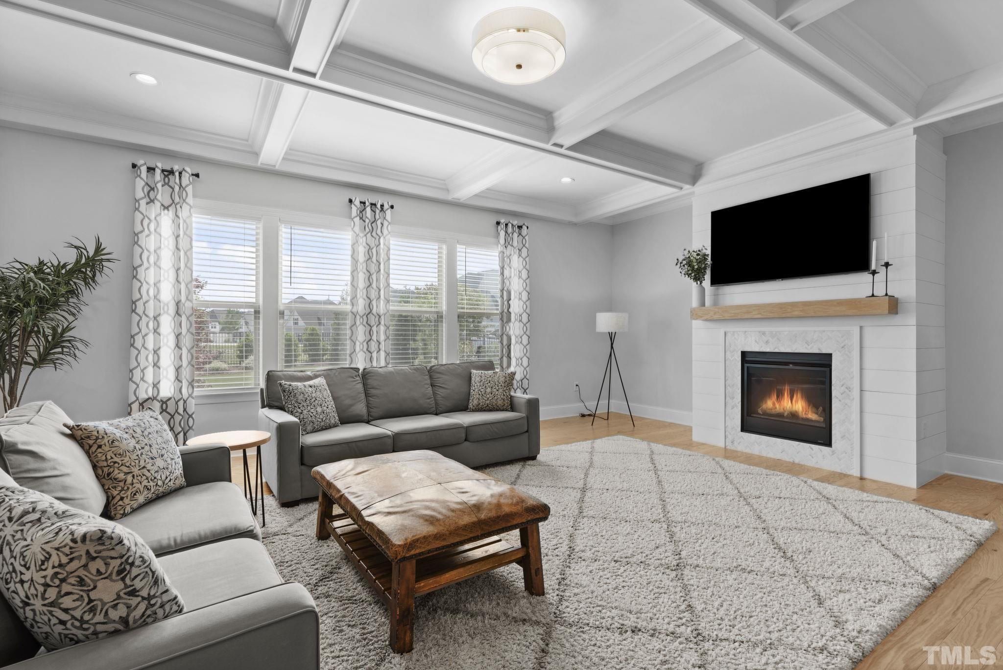 3157 Beechcroft Lane Apex, NC 27502 - Photo 11 of 42 a living room with furniture a flat screen tv and a fireplace
