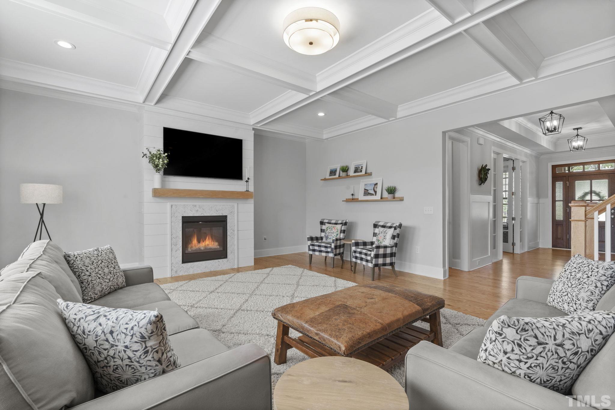 3157 Beechcroft Lane Apex, NC 27502 - Photo 14 of 42 a living room with furniture a flat screen tv and a fireplace