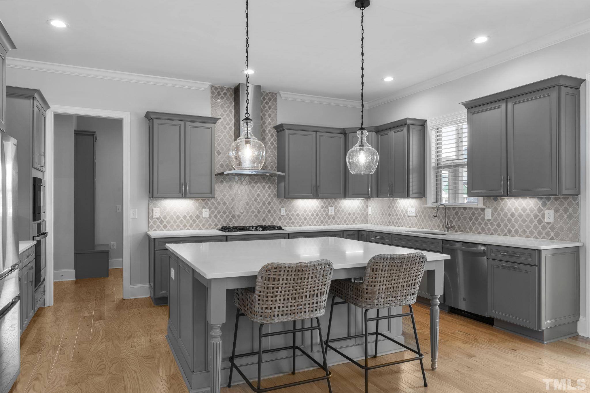 3157 Beechcroft Lane Apex, NC 27502 - Photo 16 of 42 a kitchen with stainless steel appliances granite countertop a stove a sink a refrigerator and chairs