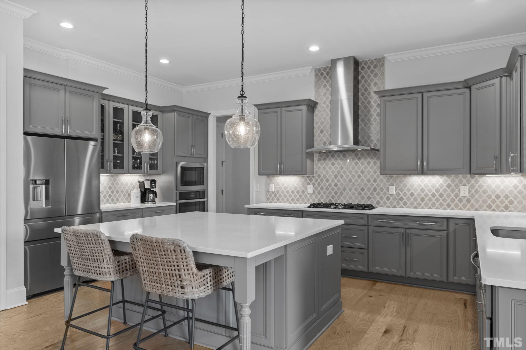 3157 Beechcroft Lane Apex, NC 27502 - Photo 17 of 42 a kitchen with stainless steel appliances granite countertop a sink a stove a refrigerator cabinets and chairs