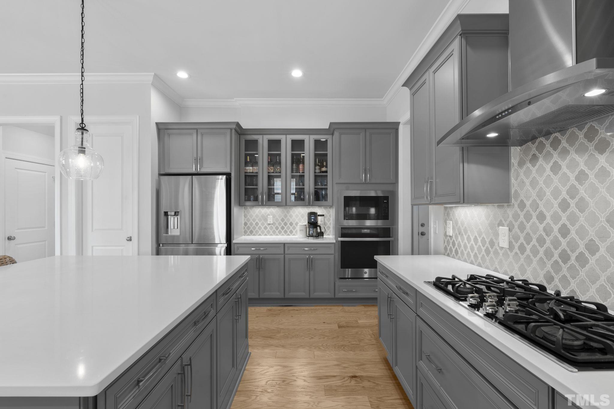 3157 Beechcroft Lane Apex, NC 27502 - Photo 18 of 42 a kitchen with stainless steel appliances kitchen island granite countertop a stove and a refrigerator