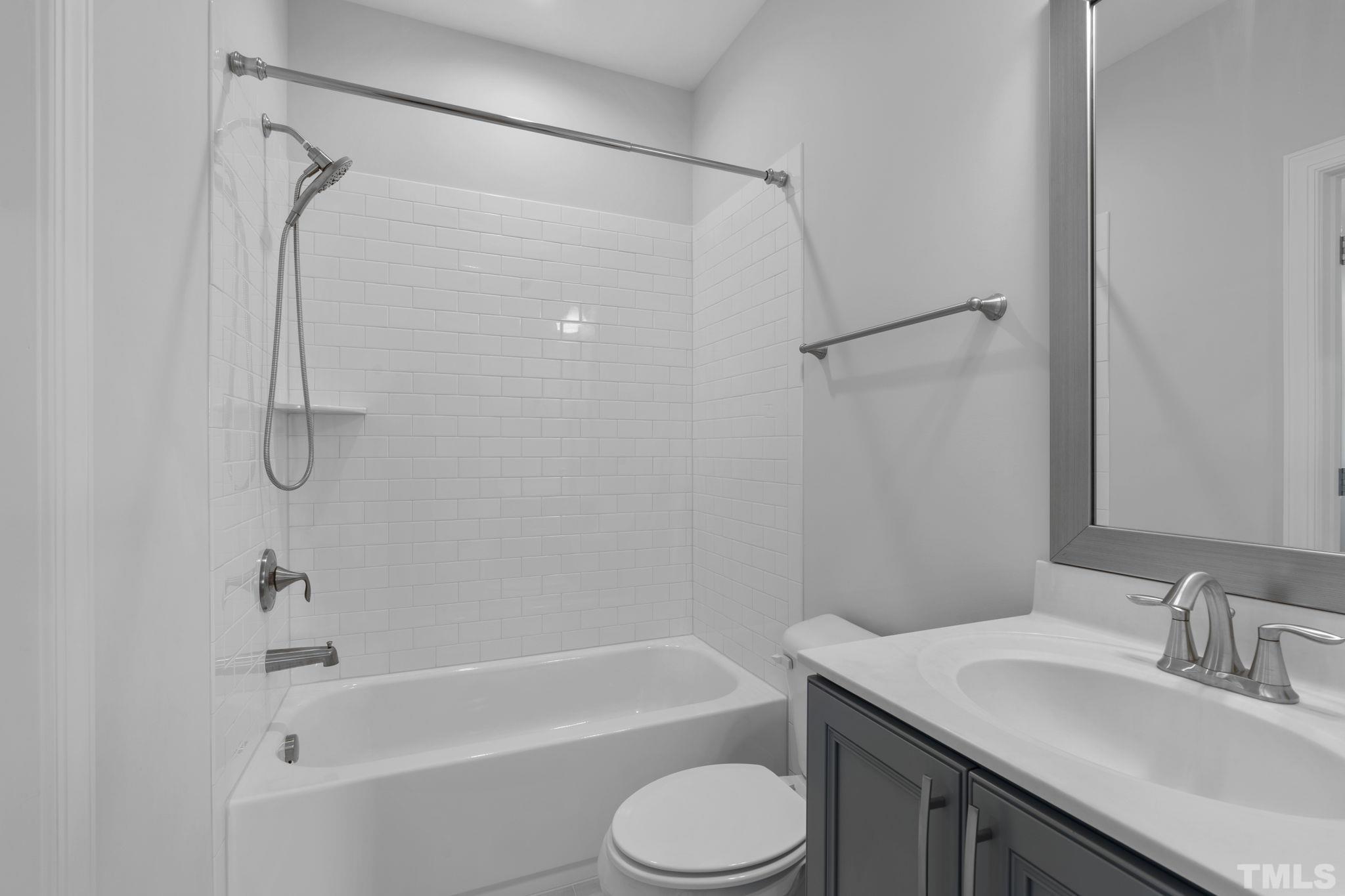 3157 Beechcroft Lane Apex, NC 27502 - Photo 29 of 42 a bathroom with a granite countertop bathtub shower sink vanity and toilet