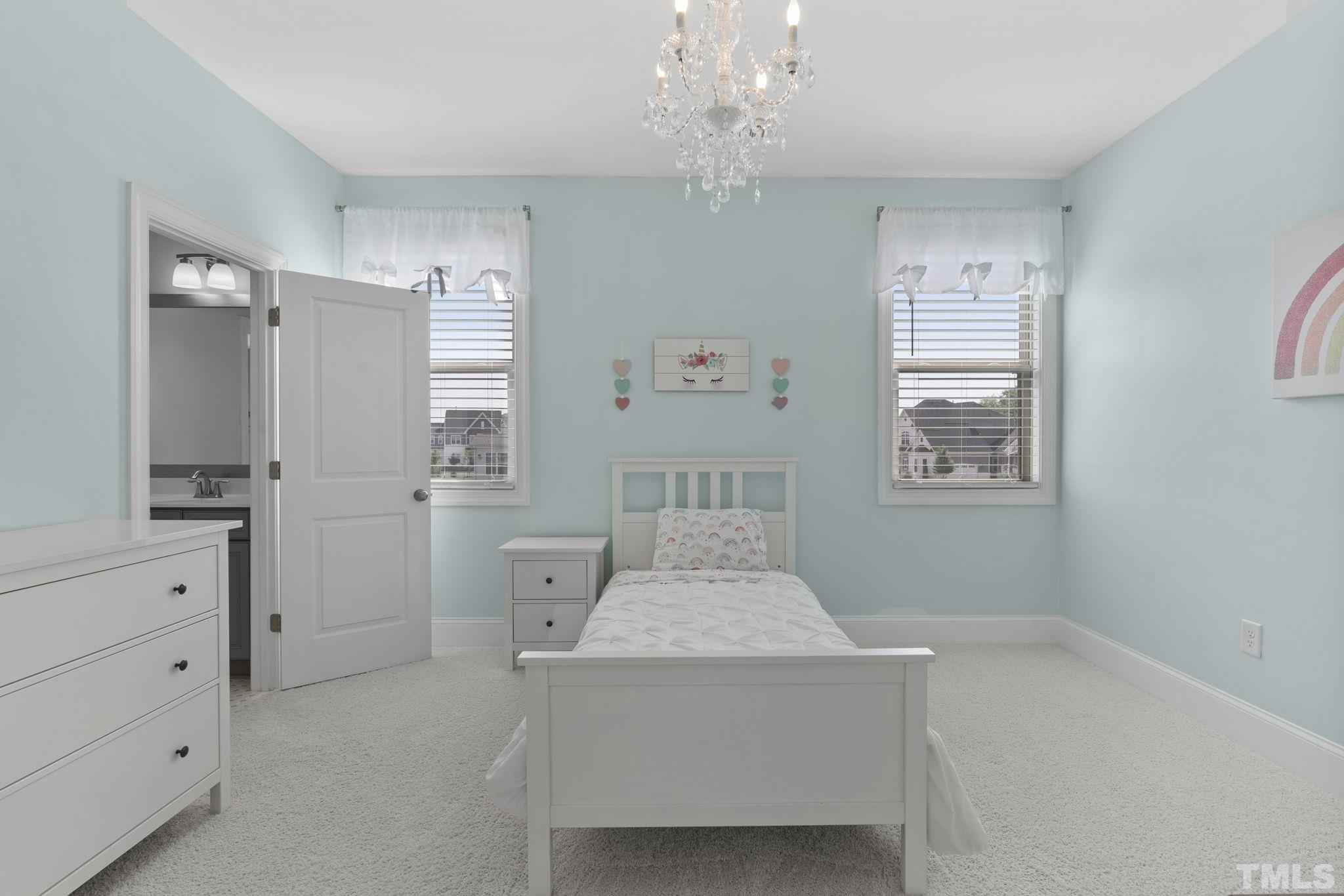 3157 Beechcroft Lane Apex, NC 27502 - Photo 30 of 42 a bedroom with a bed and a chandelier