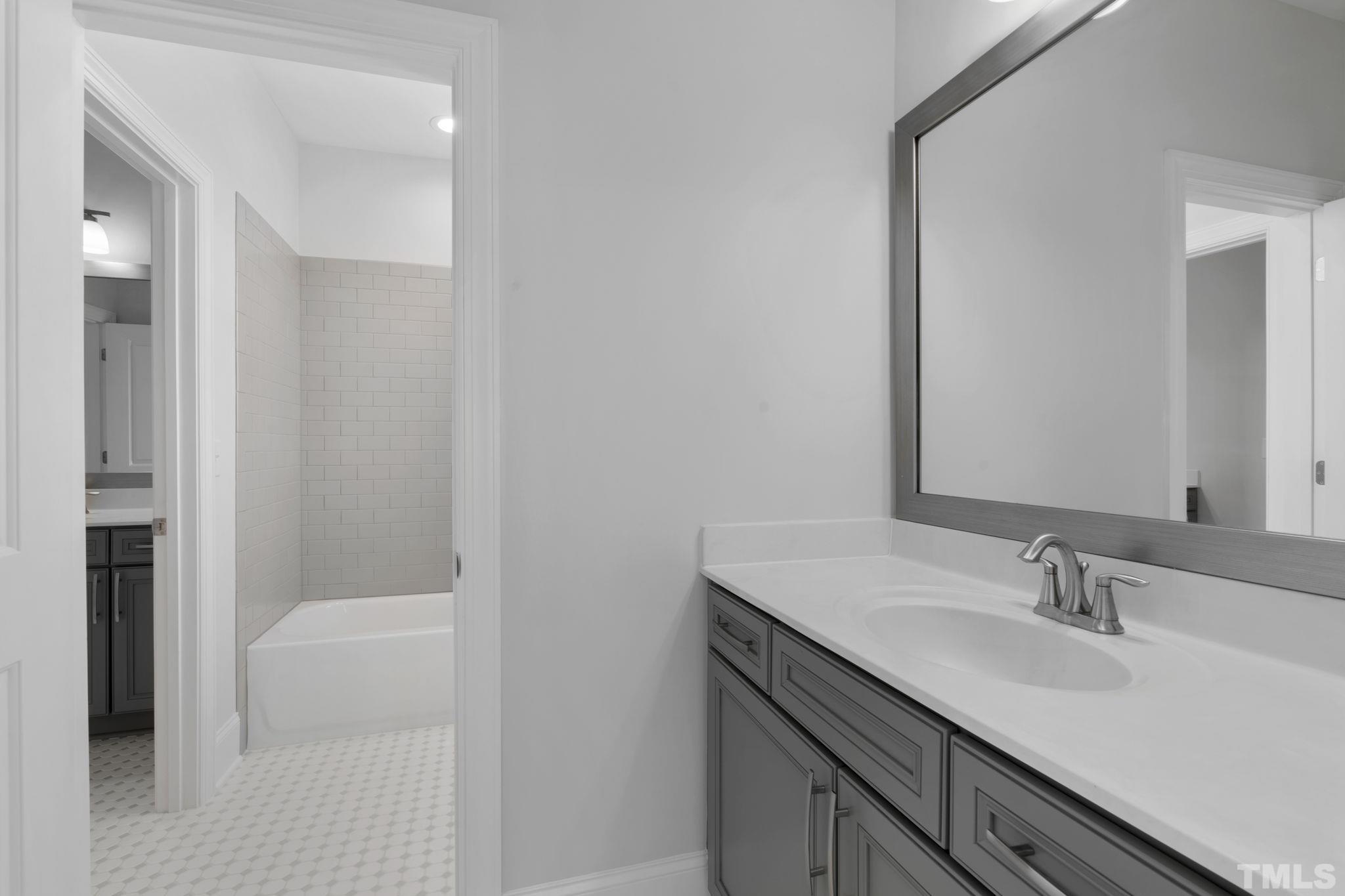 3157 Beechcroft Lane Apex, NC 27502 - Photo 31 of 42 a bathroom with a sink a toilet a shower and a mirror