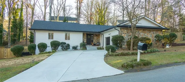 a backyard of a house with plants and outdoor seating