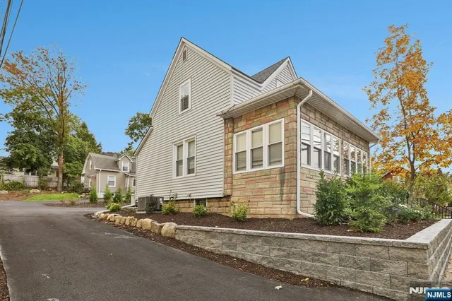 a view of an empty room with wooden floor and stairs