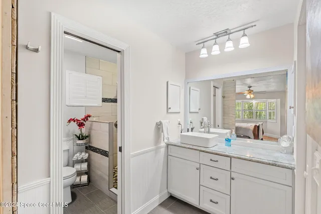 a bathroom with a granite countertop shower a sink and mirror