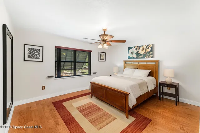a bedroom with a bed lamp on table and a window