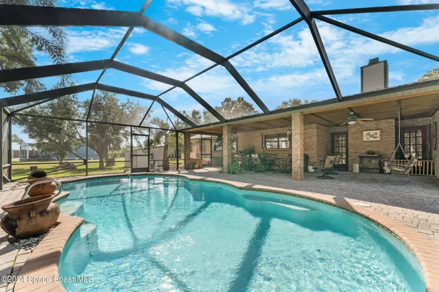a view of a backyard patio with swimming pool