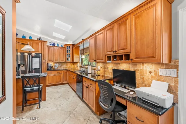 a kitchen with stainless steel appliances a stove top oven refrigerator and a sink
