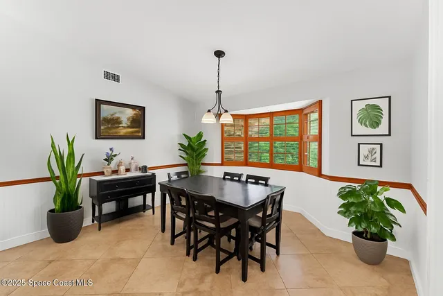 a dining room with furniture and potted plant